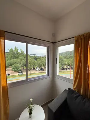 a living room with two windows and a couch at Complejo playa de oro 3 in Villa Carlos Paz