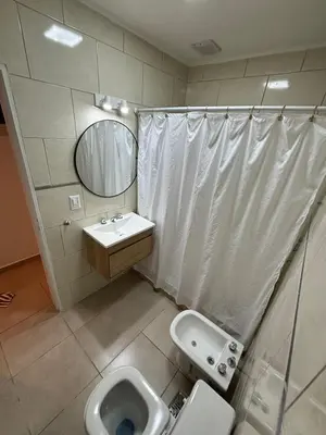 a bathroom with a toilet and a sink and a mirror at Complejo playa de oro 3 in Villa Carlos Paz