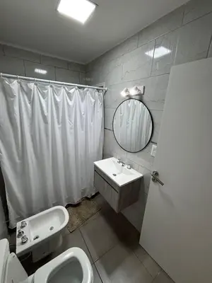 a bathroom with a sink and a toilet and a mirror at Complejo playa de oro 3 in Villa Carlos Paz
