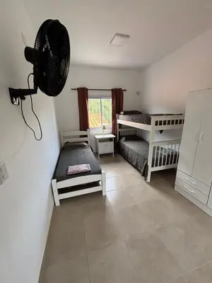 a bedroom with two bunk beds and a fan at Complejo playa de oro 3 in Villa Carlos Paz