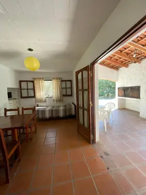 a living room with a table and a bedroom at Cabañas Aaron in Villa de Las Rosas