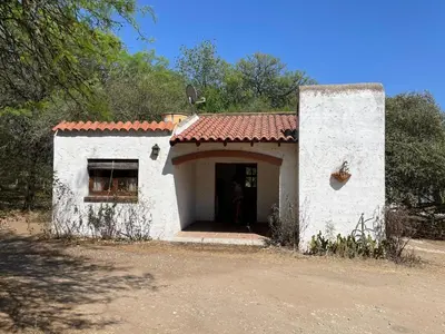 a small white building with a red roof at Cabañas Aaron in Villa de Las Rosas