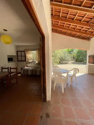 a patio with a table and chairs and a bed at Cabañas Aaron in Villa de Las Rosas