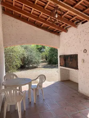 a patio with a table and chairs and a fireplace at Cabañas Aaron in Villa de Las Rosas