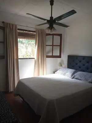a bedroom with a bed and a ceiling fan at Cabañas Aaron in Villa de Las Rosas