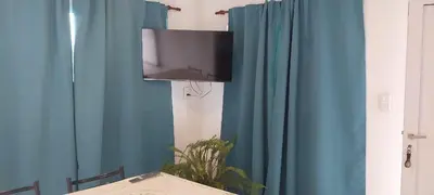 a flat screen tv hanging from a blue curtain at CASA - HAUS - Villa Cura Brochero in Villa Cura Brochero
