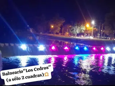 a night view of a river with colorful lights at CASA - HAUS - Villa Cura Brochero in Villa Cura Brochero