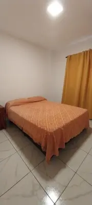 a bed sitting in a room with a curtain at CASA - HAUS - Villa Cura Brochero in Villa Cura Brochero