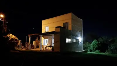 a small building with a table in front of it at night at Big House in Merlo