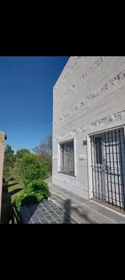 a white brick building with barred windows on it at Big House in Merlo