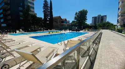a swimming pool with chaise lounge chairs and a swimming pool at Dpto 1 dormitorio-Zona Norte in Cordoba