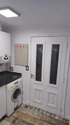 a kitchen with a washing machine and a door at La Casa De Los Recuerdos in Villa Carlos Paz