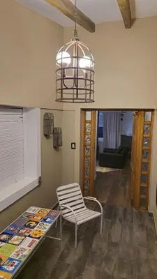 a room with a chair and a table and a lamp at La Casa De Los Recuerdos in Villa Carlos Paz