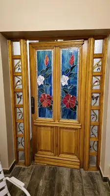 a wooden door with a window with flowers on it at La Casa De Los Recuerdos in Villa Carlos Paz