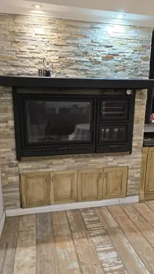 a large entertainment center with a television on a brick wall at La Casa De Los Recuerdos in Villa Carlos Paz