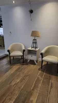 two chairs and a table with a lamp in a room at La Casa De Los Recuerdos in Villa Carlos Paz
