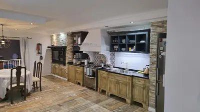 a large kitchen with wooden cabinets and a sink at La Casa De Los Recuerdos in Villa Carlos Paz