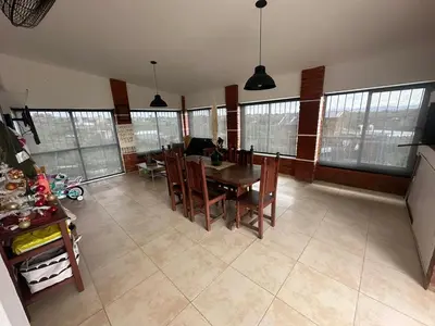 a living room with a dining room table and chairs at Casa en Tanti con pileta in Tanti