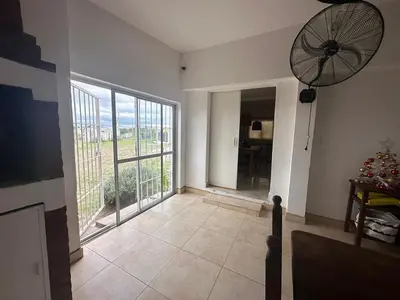a living room with a large window and a fan at Casa en Tanti con pileta in Tanti
