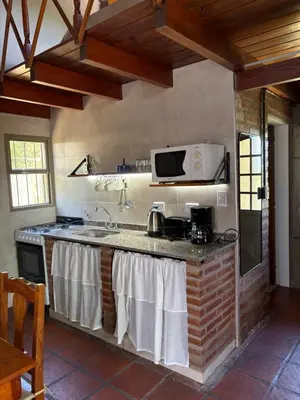 a kitchen with a stove and a microwave at Sierra Dulce in Mina Clavero