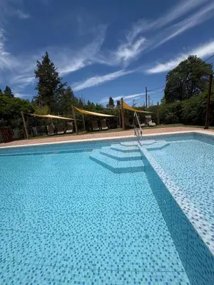 a large blue swimming pool with a volley ball net at Sierra Dulce in Mina Clavero