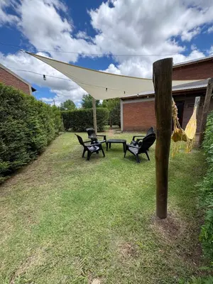 a picnic table and chairs under a tent in a yard at Sierra Dulce in Mina Clavero