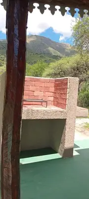 a bench sitting on top of a building with a cross at Los Jilgueros in Los Hornillos