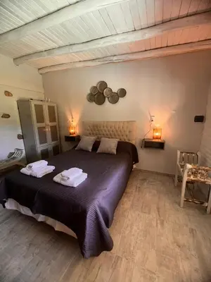 a bedroom with a large bed with towels on it at Los Jilgueros in Los Hornillos