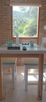 a table with two bowls on it in a room with a window at Los Jilgueros in Los Hornillos