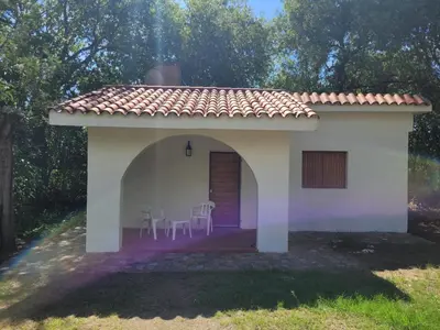 a small white house with chairs in front of it at Don Juan M Cabañas in Villa de Las Rosas
