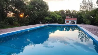 a swimming pool with a reflection of the sky in the water at Don Juan M Cabañas in Villa de Las Rosas