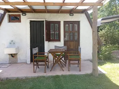 a wooden table and chairs in front of a house at Alpinas El Chusmo in Villa Ciudad Parque