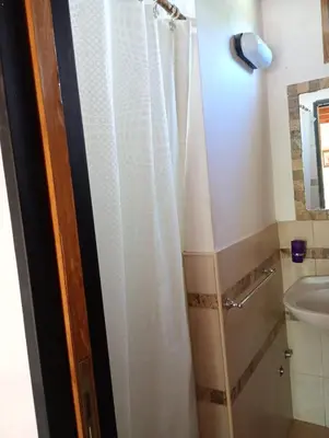a bathroom with a shower curtain and a sink at Alpinas El Chusmo in Villa Ciudad Parque