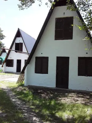 a white building with black doors and windows at Alpinas El Chusmo in Villa Ciudad Parque