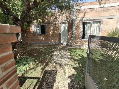 an empty yard with a fence in front of a building at Los Tilos in Mina Clavero