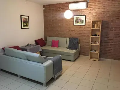 a living room with two couches and a brick wall at Los Tilos in Mina Clavero