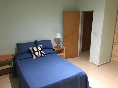 a bedroom with a blue bed with a pillow on it at Los Tilos in Mina Clavero