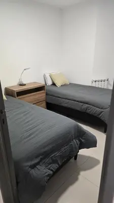 two beds in a room with a nightstand and a bed sidx sidx at COFICO DPTO de CATEGORIA in Cordoba