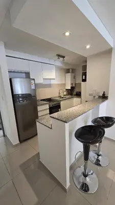 a kitchen with a counter and two bar stools at COFICO DPTO de CATEGORIA in Cordoba