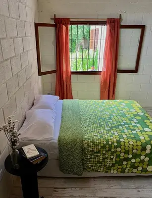 a bed in a room with a window and a table at La Donosita in La Carolina in La Carolina