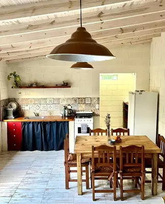 a kitchen with a wooden table with chairs and a refrigerator at La Donosita in La Carolina in La Carolina