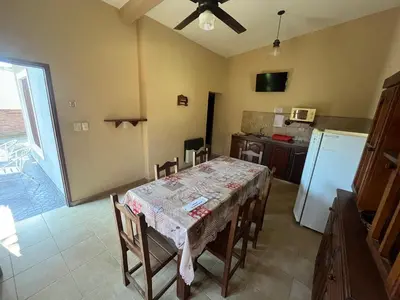 a kitchen with a table with chairs and a refrigerator at Chalet Los Aromos in Embalse