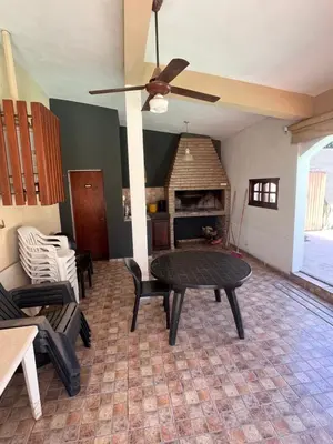 a living room with a table and a fireplace at Chalet Los Aromos in Embalse
