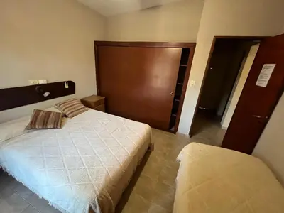 a bedroom with a bed and a wooden door at Chalet Los Aromos in Embalse
