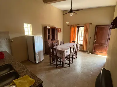 a kitchen with a table with chairs and a refrigerator at Chalet Los Aromos in Embalse
