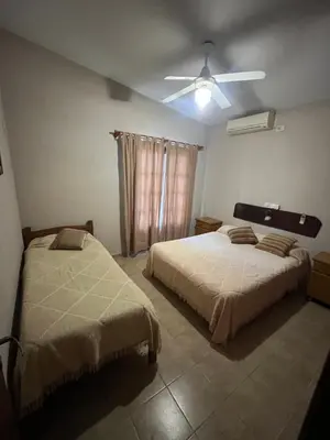 a bedroom with two beds and a ceiling fan at Chalet Los Aromos in Embalse