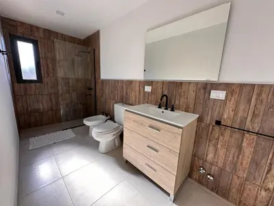 a bathroom with a toilet and a sink and a mirror at Complejo Montana in Potrero de Garay