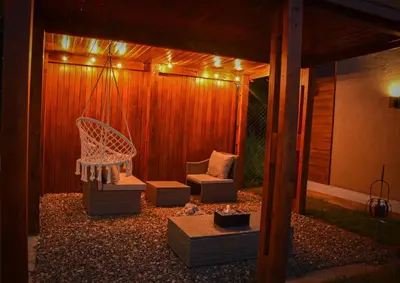 a gazebo with a bench and a chair and lights at Complejo Montana in Potrero de Garay