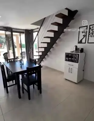 a dining room with a table and a staircase at Complejo Montana in Potrero de Garay