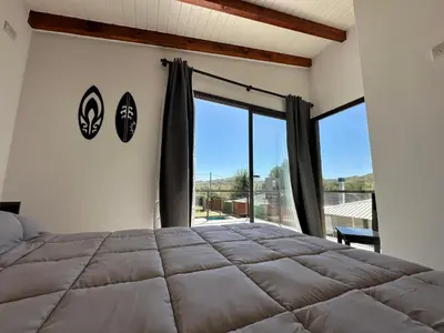 a bedroom with a large bed and a large window at Complejo Montana in Potrero de Garay